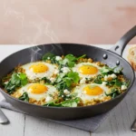 Skillet eggs with tomatillos and spinach served warm