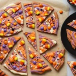 Broken shards of colorful Halloween Candy Corn Bark with candy corn, sprinkles, and swirled chocolate.