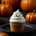 Close-up of a ghost cupcake with frosting and candy eyes.